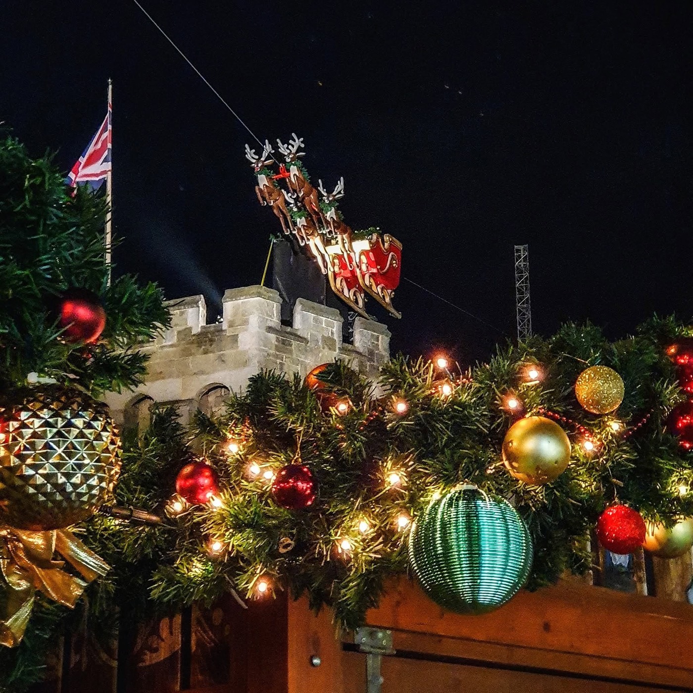 The Bargate at night, draped in Christmas garland and baubles, a Santa sleigh on top